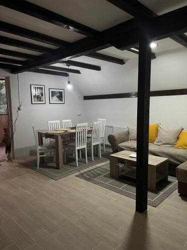 a living room with a couch and a table and chairs at Zavojsko jezero - Vila Jezero in Pirot