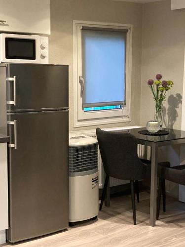 a kitchen with a refrigerator and a table and a window at S-CHALET Camping mit Comfort im Schwarzwald in Steinach