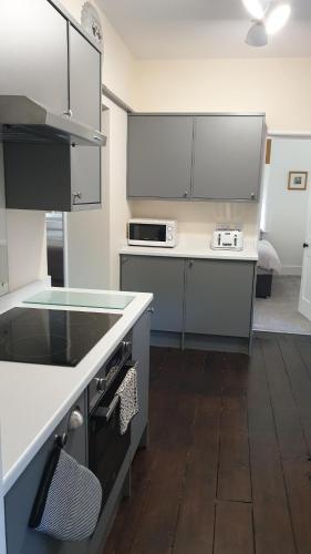 a kitchen with white cabinets and a counter top at Beautiful Garden Apartment in Leafy St Leonards 5 Mins to Beach in St. Leonards
