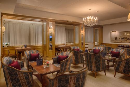 a restaurant with tables and chairs and a chandelier at Bellavista Relax Hotel in Levico Terme