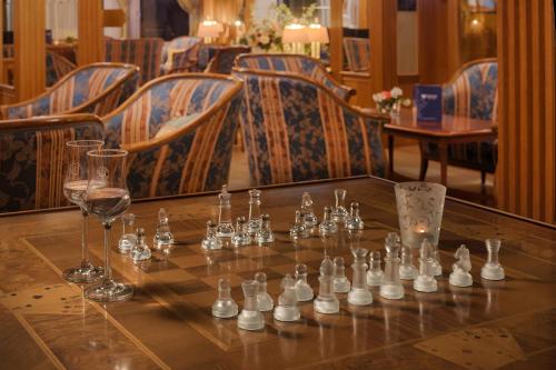 a chess set on a table with wine glasses at Bellavista Relax Hotel in Levico Terme