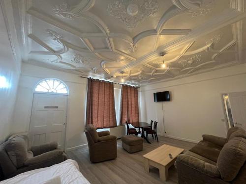 un salon avec un plafond à caissons et une table dans l'établissement Spacious Entire Flat, 1, à Great Yarmouth