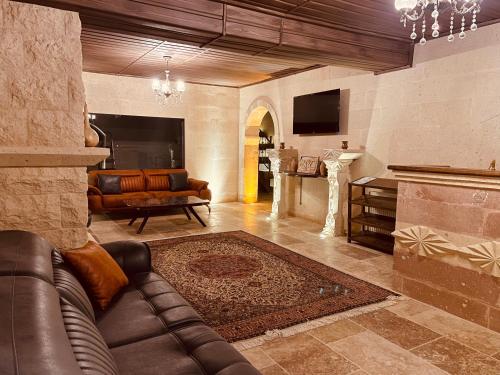 a living room with a leather couch and a table at Virtus Cappadocia Hotel Göreme in Goreme