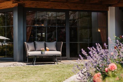 a couch on a patio in front of a building at Gut Berg Naturhotel in Sankt Johann im Pongau