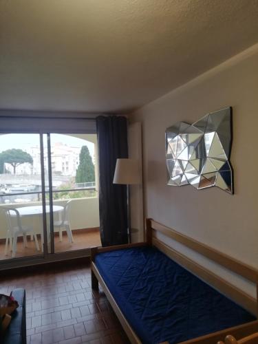 - une chambre avec un lit, une lampe et une table dans l'établissement Cap D 'Agde Studio cabine 5 personnes, vue chenal, au Cap d'Agde