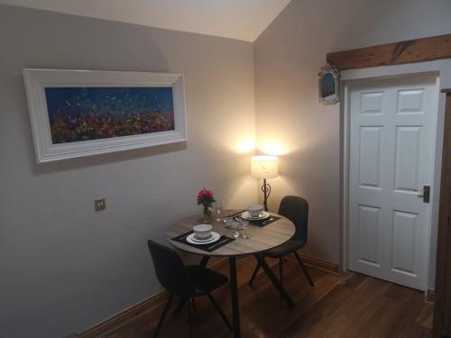una mesa de comedor con sillas y una pintura en la pared en Catstone Lodge 