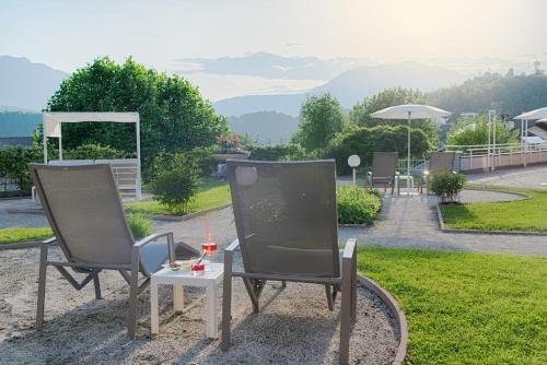 two chairs and a table with a drink on it at Bellavista Relax Hotel in Levico Terme