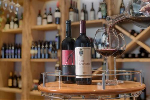 two bottles of wine sitting on a barrel next to a glass at Bellavista Relax Hotel in Levico Terme