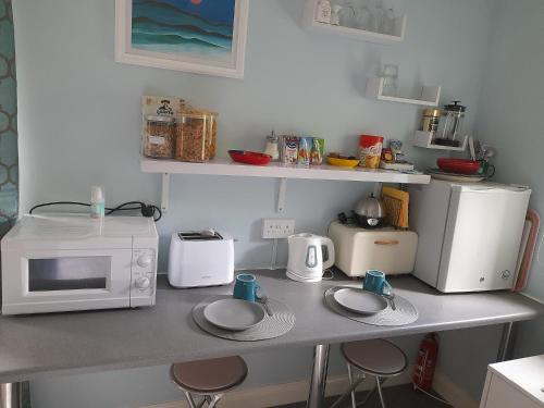 a kitchen counter with a microwave and appliances on it at Santi Bhavana Bed & Breakfast in Westbury