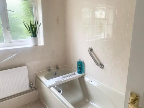 a bathroom with a bath tub and a sink at Penderels, Willersey in Broadway