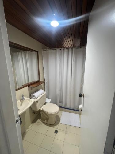 a bathroom with a toilet and a sink at Hotel Caucasia in Caucasia