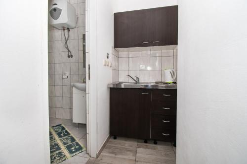 La petite salle de bains est pourvue d'un lavabo et de toilettes. dans l'établissement Apartments Lily, à Batalaži