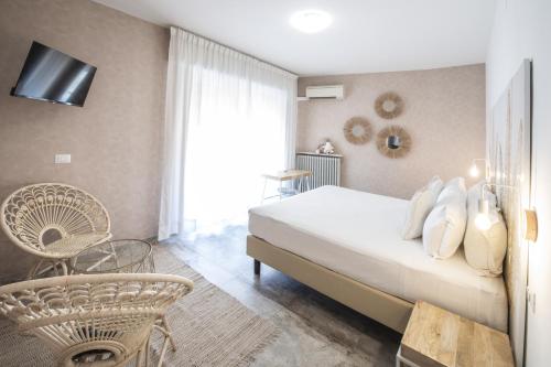 a bedroom with a bed and a chair and a window at Hotel Brennero in Verona