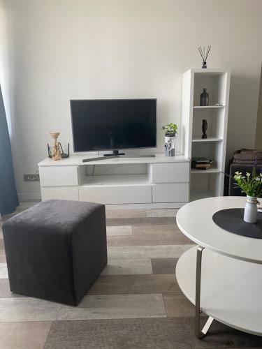 a living room with a tv on a white entertainment center at Nemuno apartamentai in Panevėžys