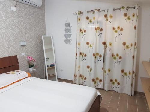 - une chambre avec un lit et un rideau de douche avec des fleurs dans l'établissement Ariosto apartment, à Mondragone