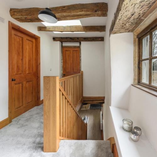 a room with a staircase and a wooden door at 10 Bed Stunning House in village, with Hot Tub in Ovingham