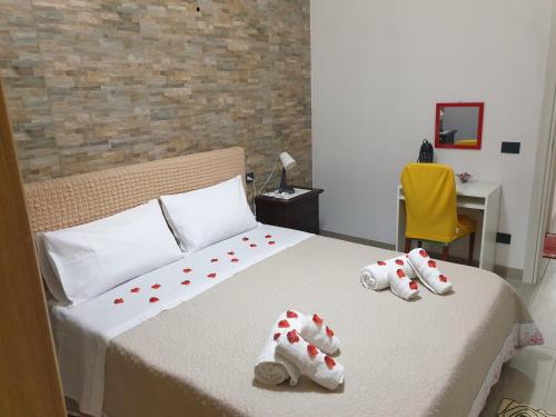 een slaapkamer met een bed met handdoeken erop bij Villino La gioia di Corrado in Avola