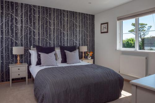 a bedroom with a large bed and a window at Furlong Cottage @ Higher Stancombe Farm in Kingsbridge