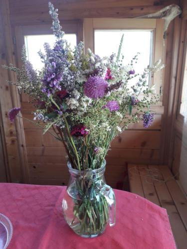 a vase filled with purple flowers on a table at Karadžić in Žabljak