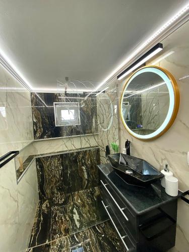 La salle de bains est pourvue d'un lavabo noir et d'un miroir. dans l'établissement Casa Dutu, à Tuzla