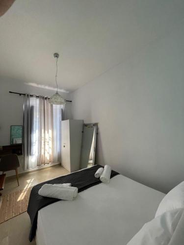 a white bedroom with a bed and a refrigerator at Veneto's Garden in Kardamili
