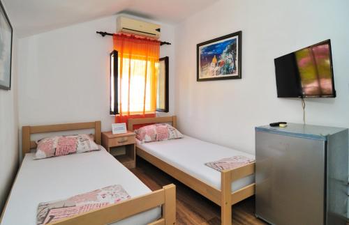 a room with two beds and a television in it at Sofia Rooms in Tivat