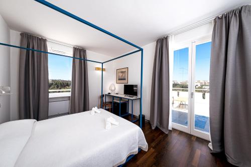 um quarto de hotel com uma cama e uma grande janela em VILLA AL MARE sea, relax & wellness em Monopoli