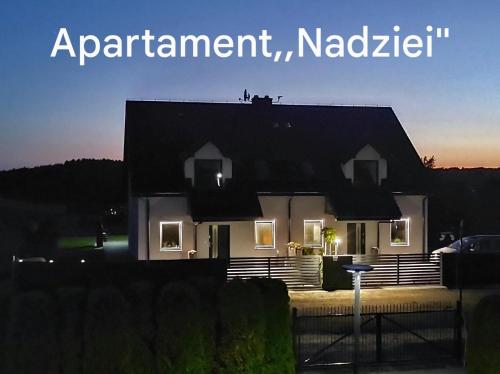 una casa por la noche con las palabras apartamento istg istg en Apartament Nadziei, en Chmielno