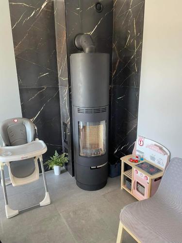a living room with a fireplace and a chair and a table at Apartament Nadziei in Chmielno
