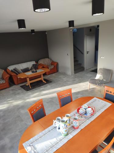 a living room with a table with cups and chairs at Apartament Nadziei in Chmielno