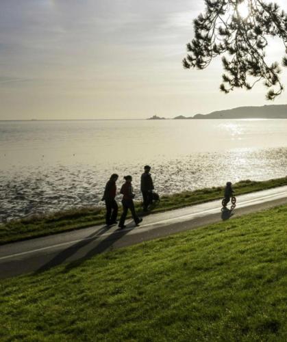 a group of people walking down a path next to the water at 40 Carlton Tce F1 in Swansea