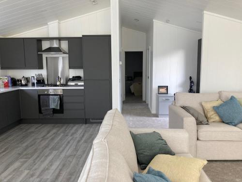 a living room with a couch and a kitchen at Beach Base Lodge, Padstow Cornwall in Padstow
