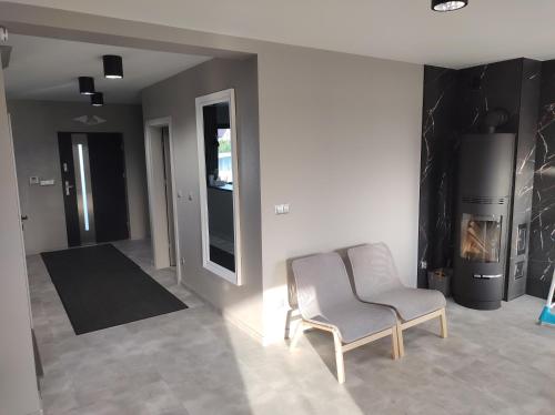 a living room with a chair and a refrigerator at Apartament Nadziei in Chmielno
