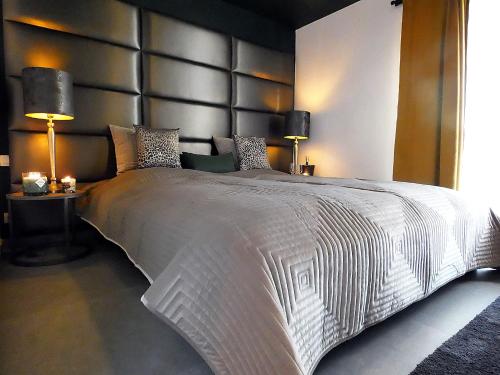 um quarto com uma grande cama branca e 2 candeeiros em SuiteDreams - Relax Suite Liège em Liège