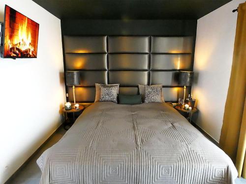 - une chambre avec un grand lit et une grande tête de lit dans l'établissement SuiteDreams - Relax Suite Liège, à Liège