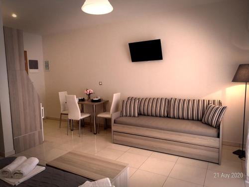a living room with a couch and a table at Adonis Apartments in Paralia Katerinis
