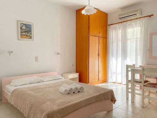 1 dormitorio con 1 cama con 2 toallas en Captain Michalis Apartments, en Galatás
