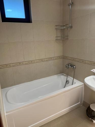 a white bath tub in a bathroom with a sink at Villa Ivana - Bay View Villas in Kosharitsa