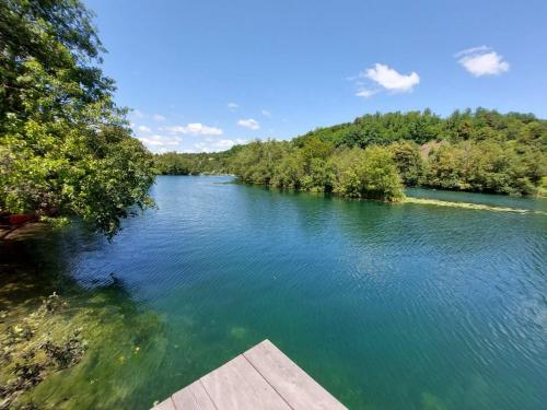 een uitzicht op een rivier met een houten dock bij Kuca za odmor Braco in Donji Zvečaj