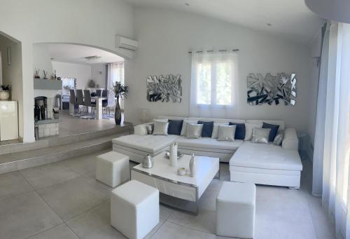- un salon avec des canapés blancs et des oreillers bleus dans l'établissement VILLA LES YUCCAS - Pool - Sea view, à Cagnes-sur-Mer
