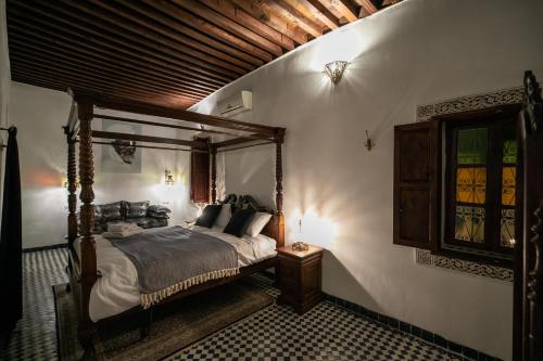 a bedroom with a canopy bed and a window at Dar Chez Khadija in Fès