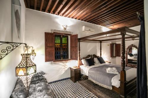 a bedroom with a canopy bed and a window at Dar Chez Khadija in Fès