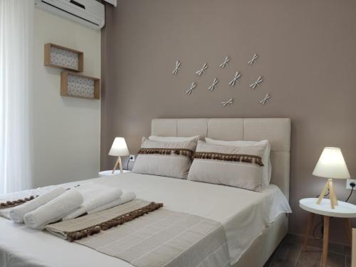 um quarto com uma grande cama branca com pássaros na parede em Stamatia Apartments em Asprovalta