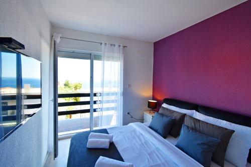 a bedroom with a large bed with a purple wall at Apartman Lukas in Rabac