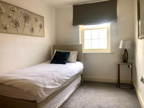 een kleine slaapkamer met een bed en een raam bij Quarry House in Stamford