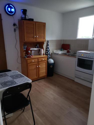 a kitchen with a table and a chair in a room at La maison des Landes in Bias