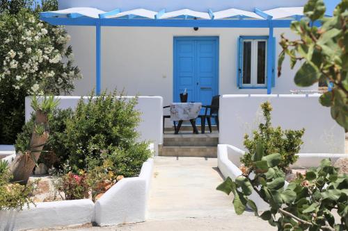 ein Haus mit blauer Tür und einigen Pflanzen in der Unterkunft Alice Maisonette & Studios in Adamas