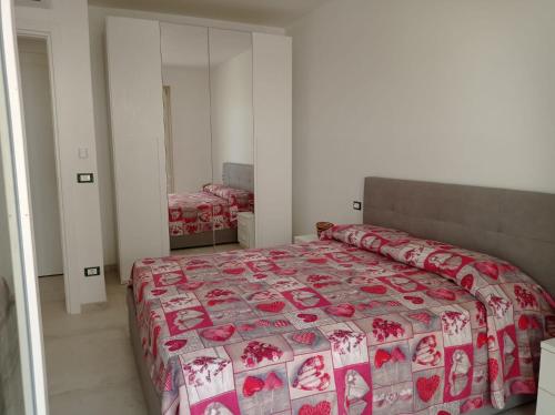a bedroom with a bed with a red and white bedspread at Gelsimori Apartments in Otranto