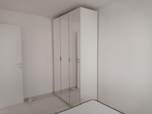 a glass shower in a white room with a mirror at Gelsimori Apartments in Otranto