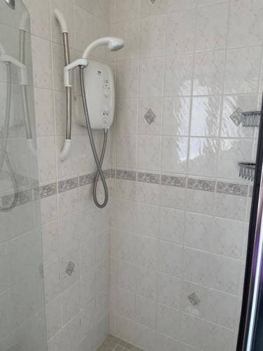 a shower with a shower head in a bathroom at Cill Cottage in Roundstone